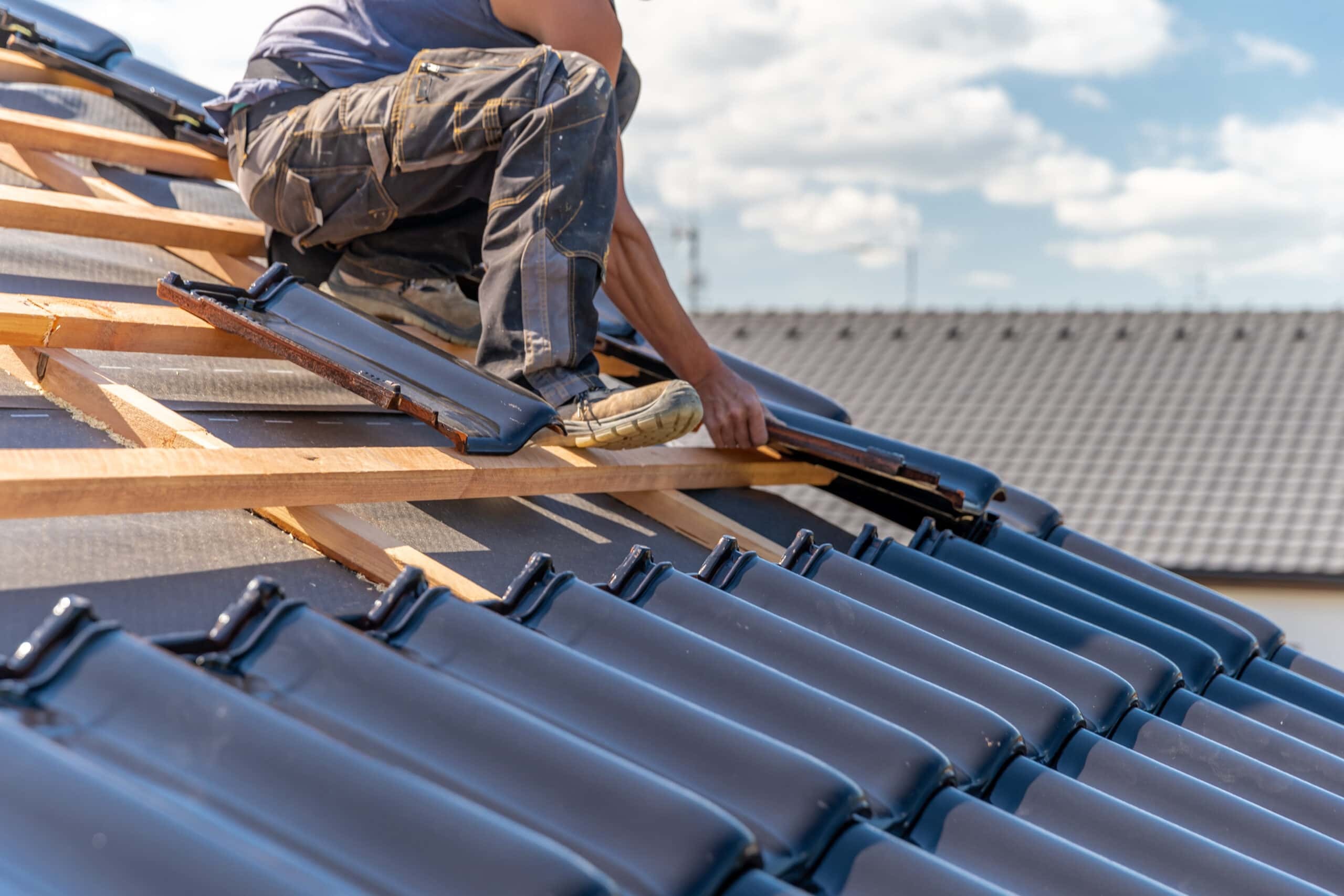 professional worker installing new roof shingles