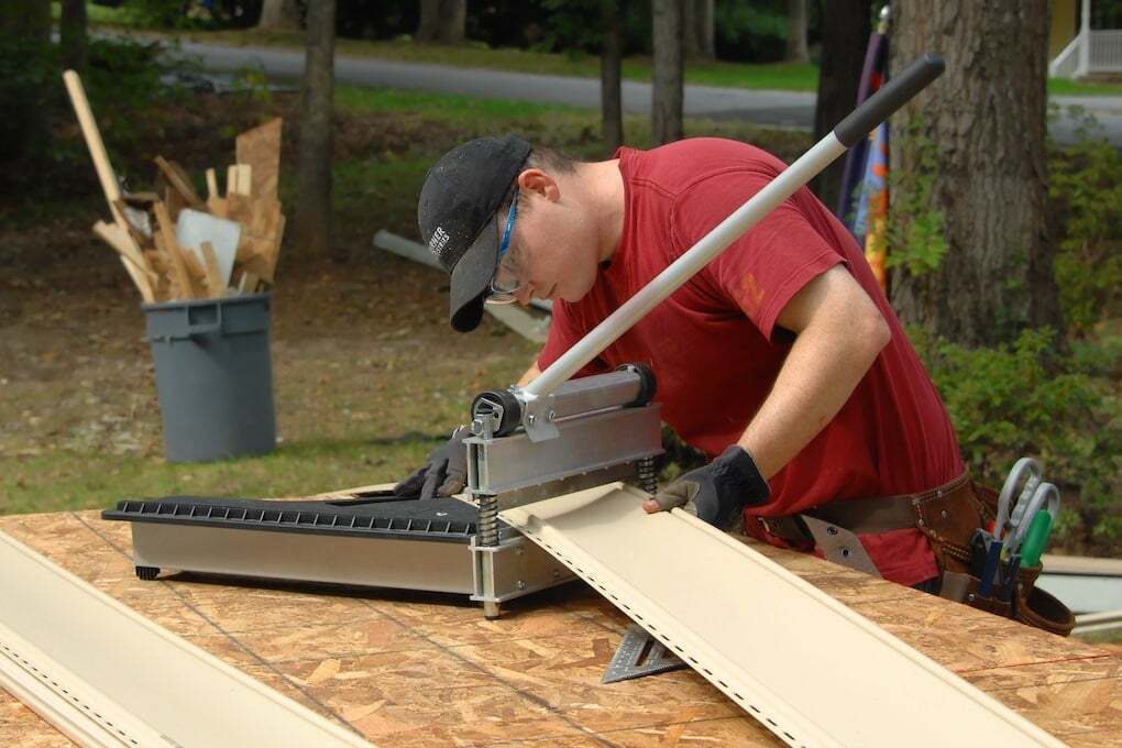 man cutting siding for home before installation: james hardie siding installation