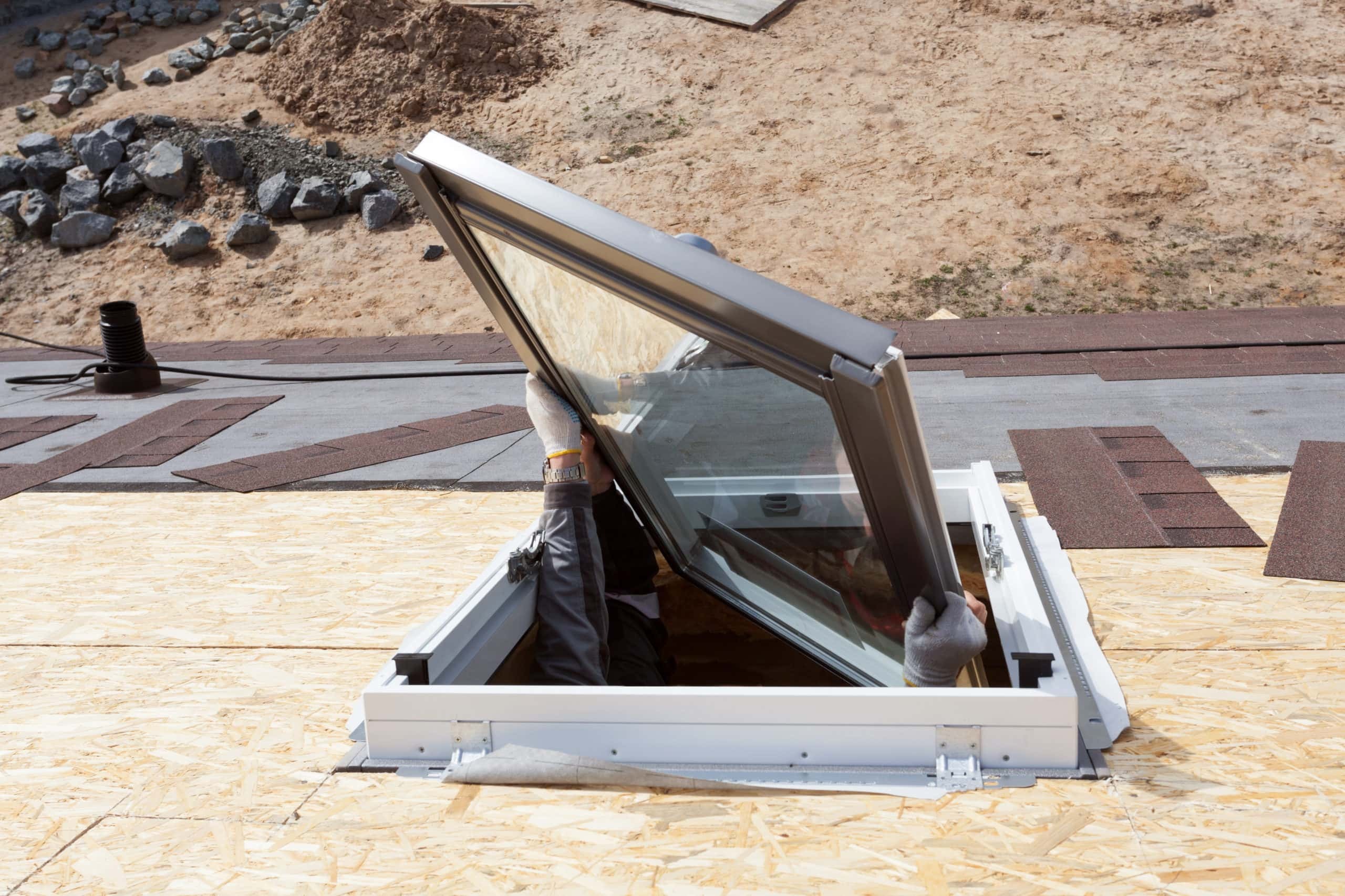 roofer placing skylight during installation