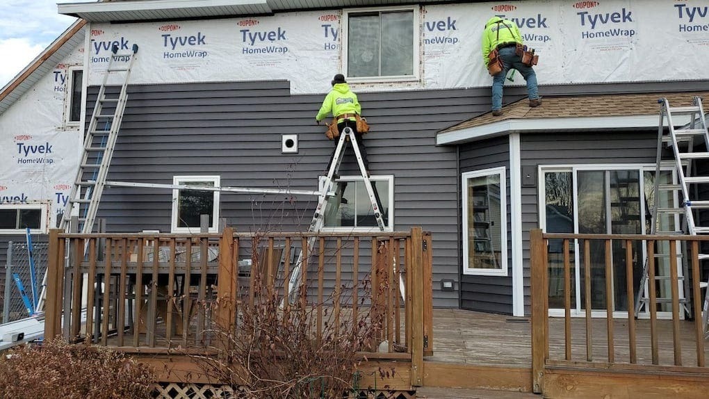 professional crew installing home siding: james hardie siding installation