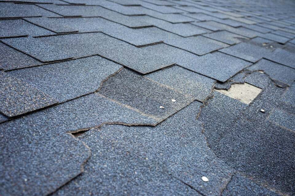 roof repair vs replacement-close up of damaged shingles