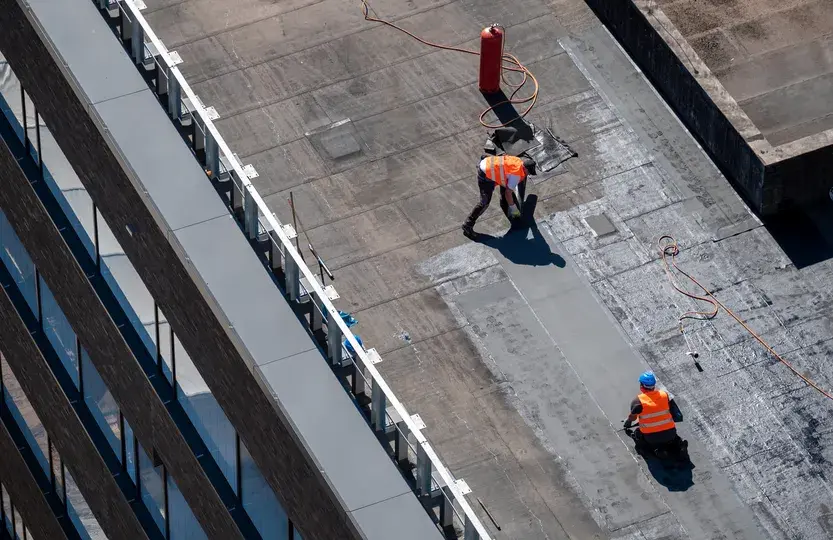 Construction workers installing a new flat roof