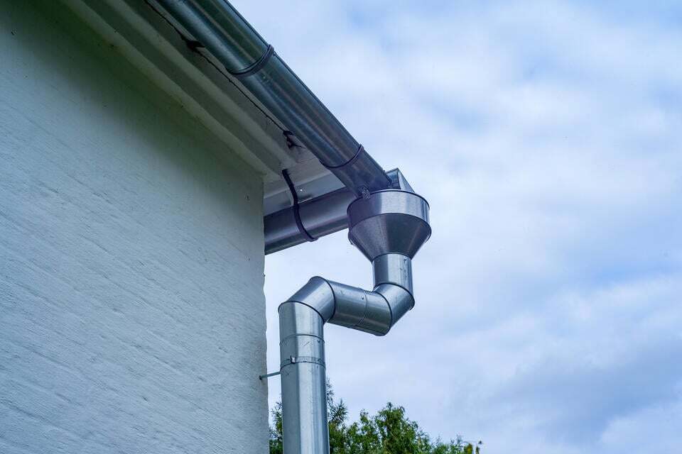aluminum gutters-metal gutter system on white brick house