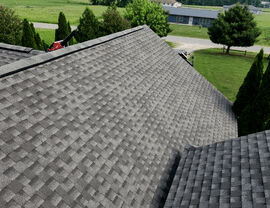Finished asphalt shingle roof showing clean valleys and ridge line