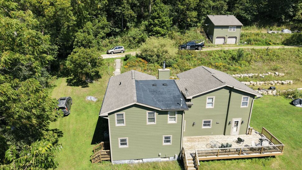 Aerial view of house with rubber roof patch and asphalt shingles
