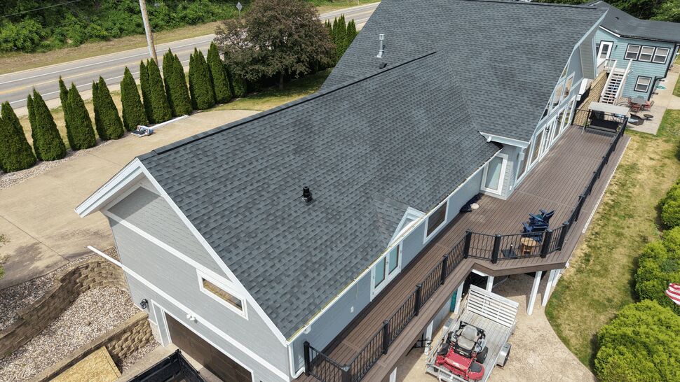Angled aerial of roof, gray siding and elevated deck
