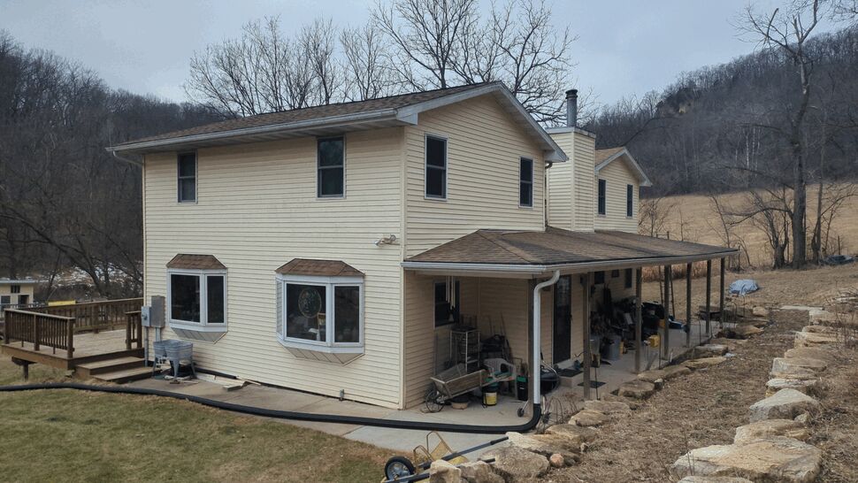Beige two-story home with seamless gutters and downspouts