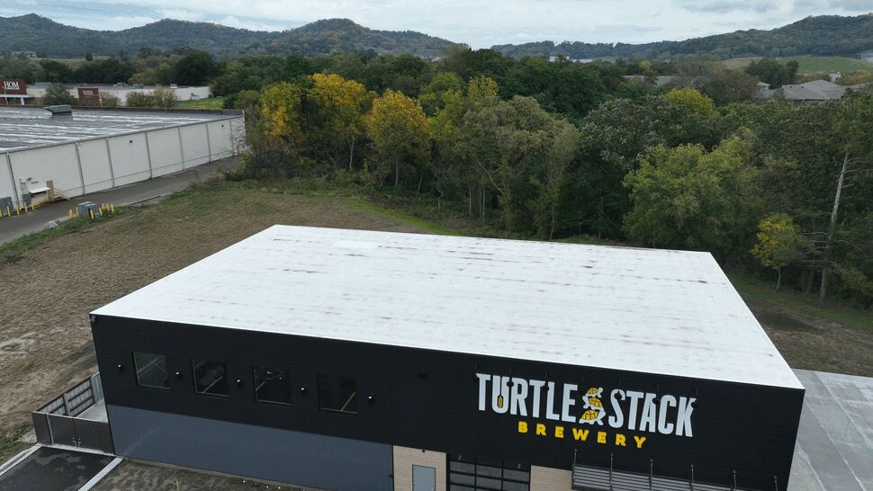White Commercial Roof Aerial | First American Roofing & Siding Inc Aerial view of a white commercial roof above Turtle Stack Brewery.