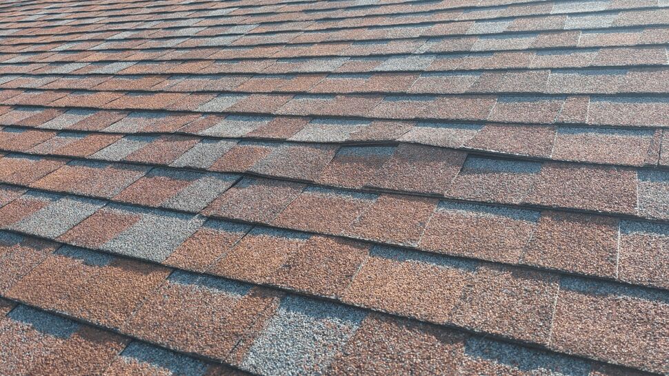 Close-up of layered brown and gray architectural roof shingles
