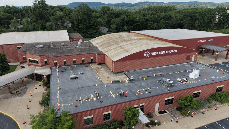 Aerial view of commercial roofing work at a brick church complex