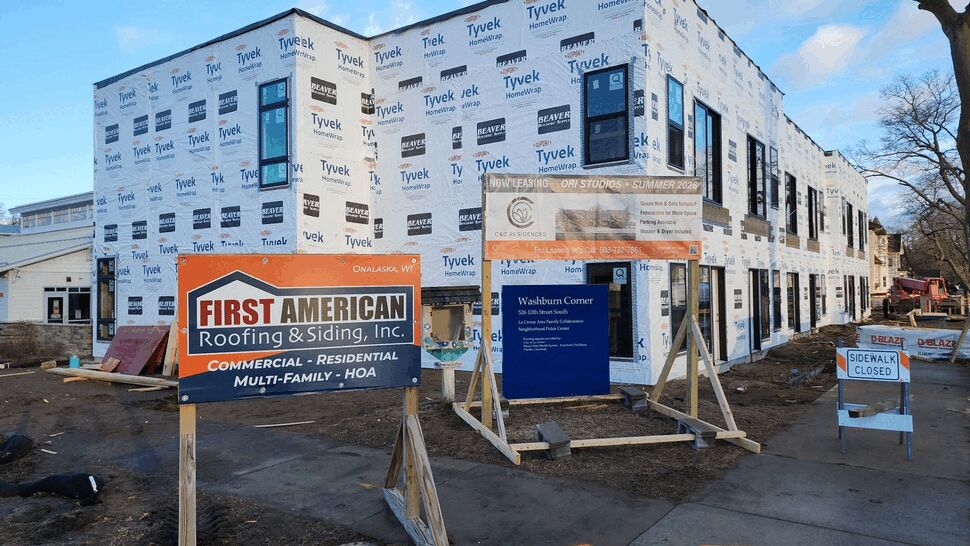 Commercial building under construction with Tyvek wrapping and company signage