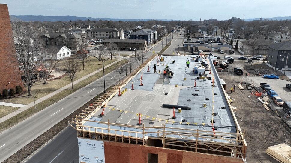 Aerial view of workers installing a flat roof on a commercial building