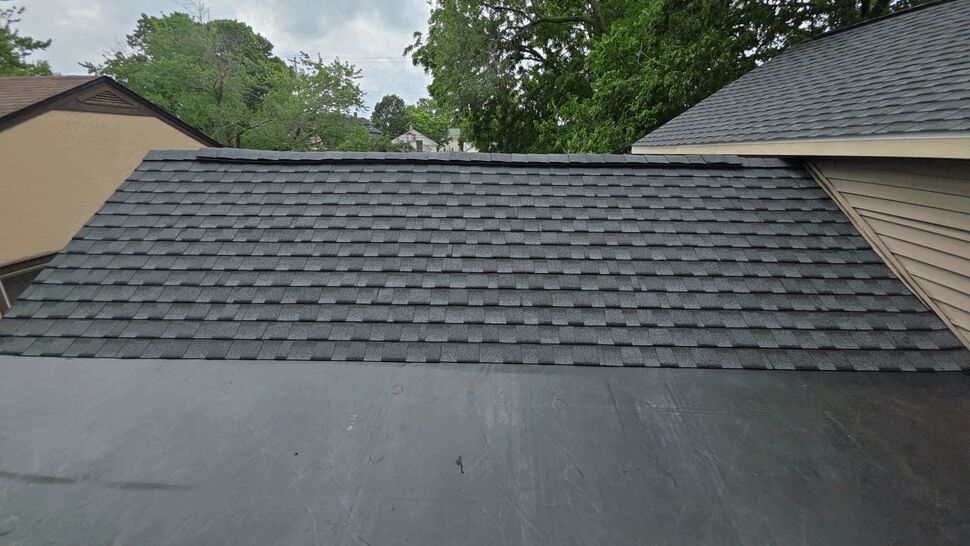 Newly installed asphalt shingles above a black rubber roof membrane.