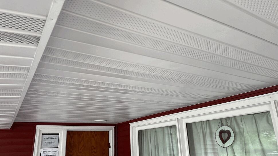 Covered Porch Aluminum Soffit | First American Roofing & Siding Inc Close view of perforated white aluminum soffit above a covered porch.