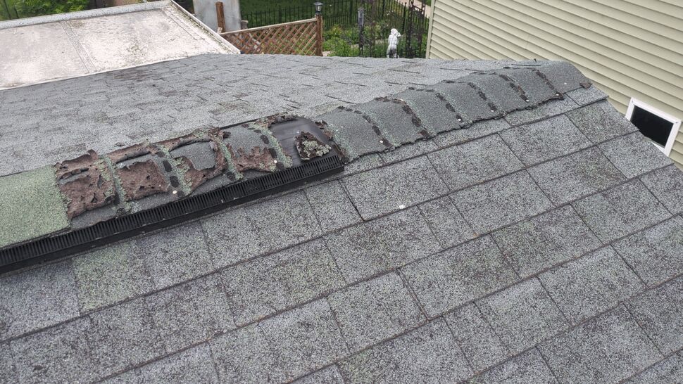 Damaged Ridge Vent and Shingles | First American Roofing & Siding Inc Damaged shingles and exposed ridge vent on a residential roof