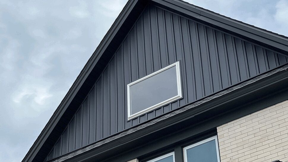 Dark Gable Board and Batten Siding | First American Roofing & Siding Inc Dark gray board and batten siding with a trimmed gable window
