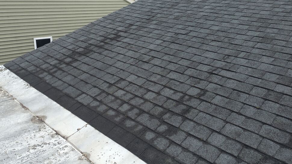 Dark Shingle Roof Slope | First American Roofing & Siding Inc Dark gray asphalt shingles covering a sloped residential roof