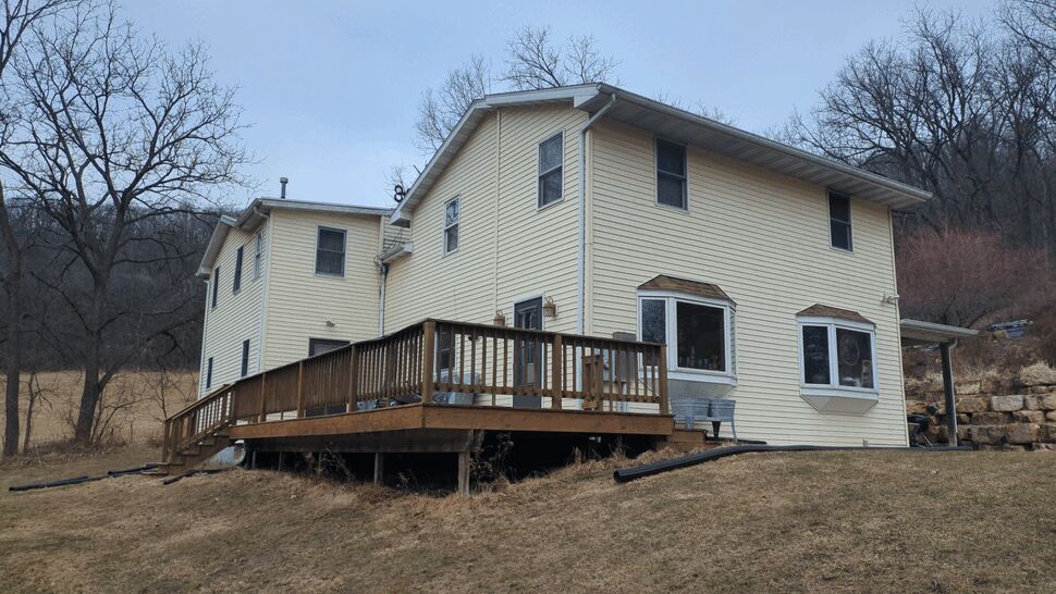 Rear deck view of home with siding and window upgrade prep
