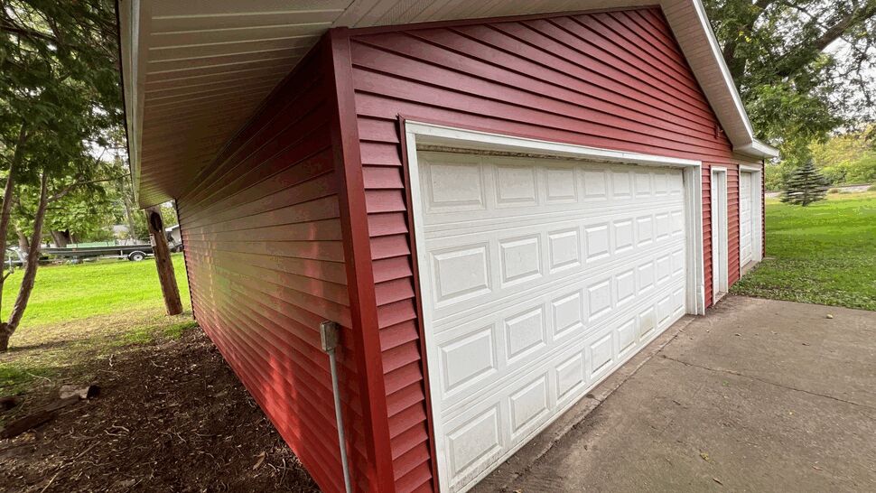 Red Garage Siding Renovation | First American Roofing & Siding Inc Detached garage featuring red siding, white garage doors, and white soffit.