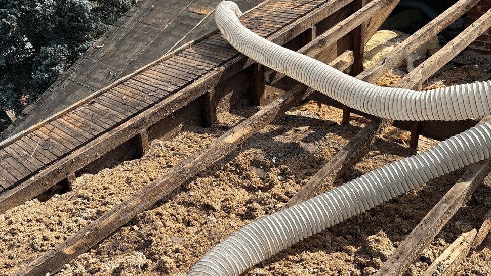 Open Roof Deck with Blown Insulation | First American Roofing & Siding Inc Open roof deck with exposed rafters and hoses for blown insulation