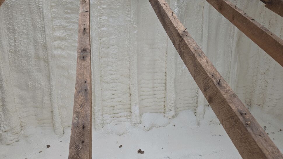 Close-up of spray foam insulation applied between attic rafters