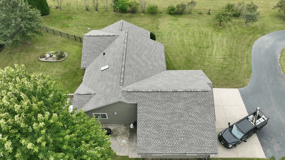 Top-down roof and gutter inspection | First American Roofing & Siding Inc Top-down drone view of house roof, gutters, and a service truck on the driveway.