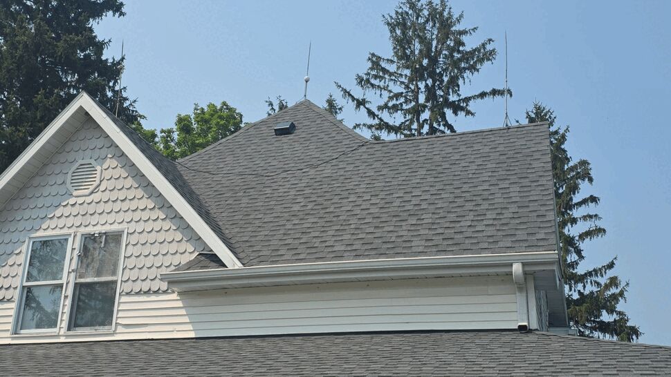 Upper Roofline and Gutter Detail | First American Roofing & Siding Inc Upper roofline with gray shingles and white gutter detail