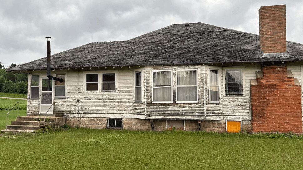 Weathered House with Peeling Siding | First American Roofing & Siding Inc Older house with peeling white siding, aged roof and brick chimney