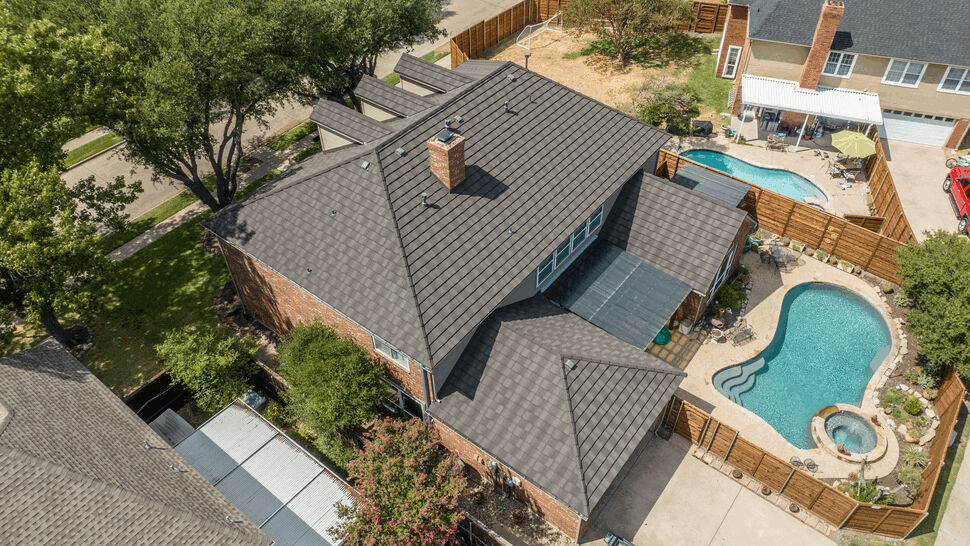 Aerial view of house with metal shake roof and backyard pool