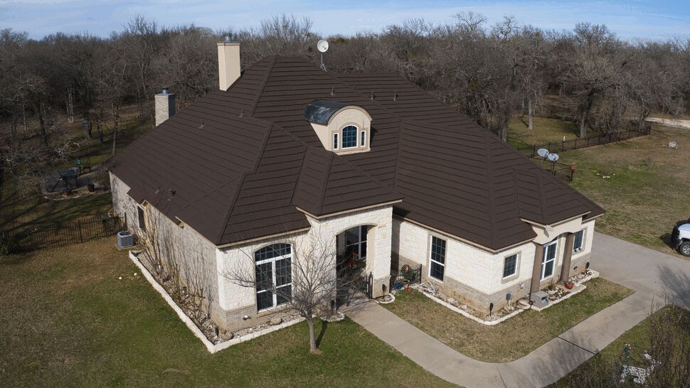 Dark Brown Metal Tile Roof | US Metal Roofing Consortium Aerial view of a house with a dark brown metal tile roof.
