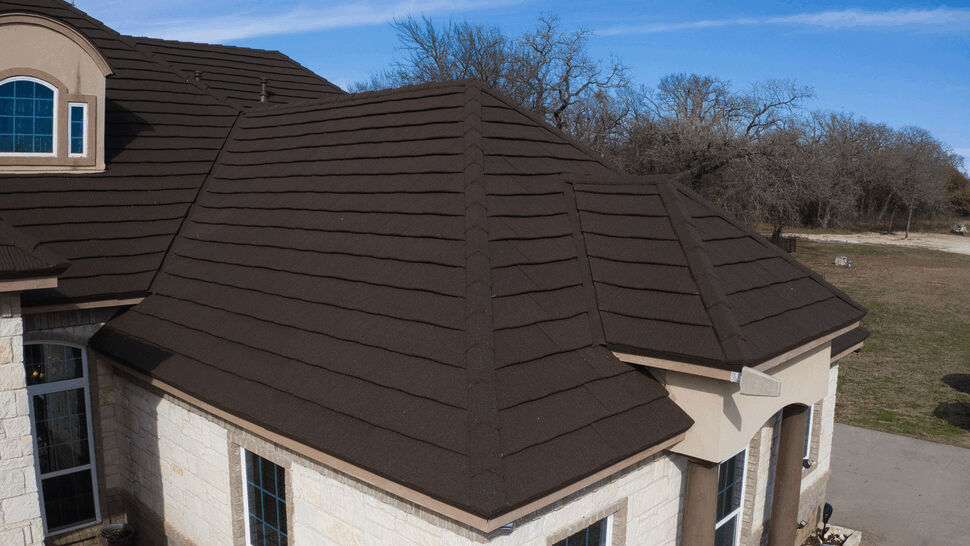 Close-up of dark metal roof detailing | US Metal Roofing Consortium Close-up of dark brown metal roof tiles and ridges on a residential home.