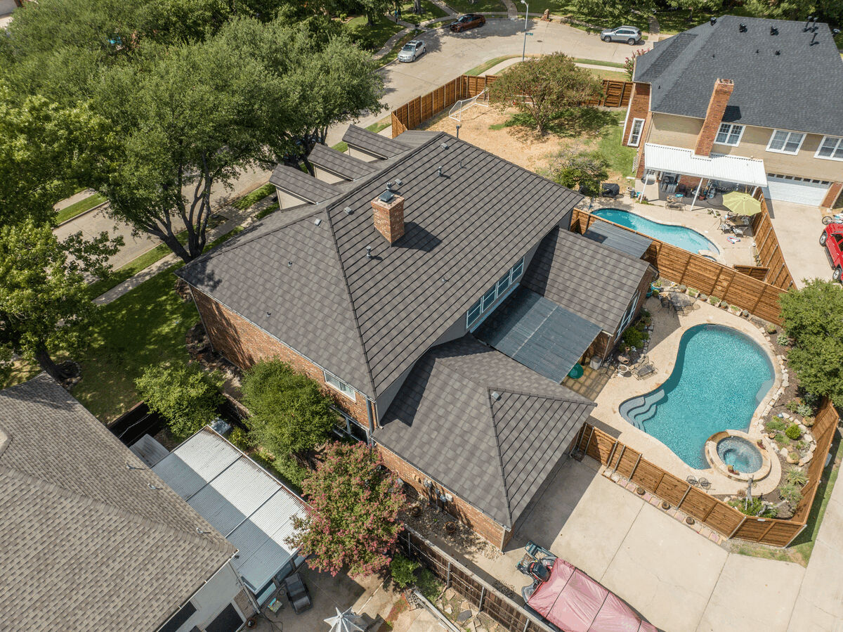Aerial view of house with metal shake roof and backyard pool