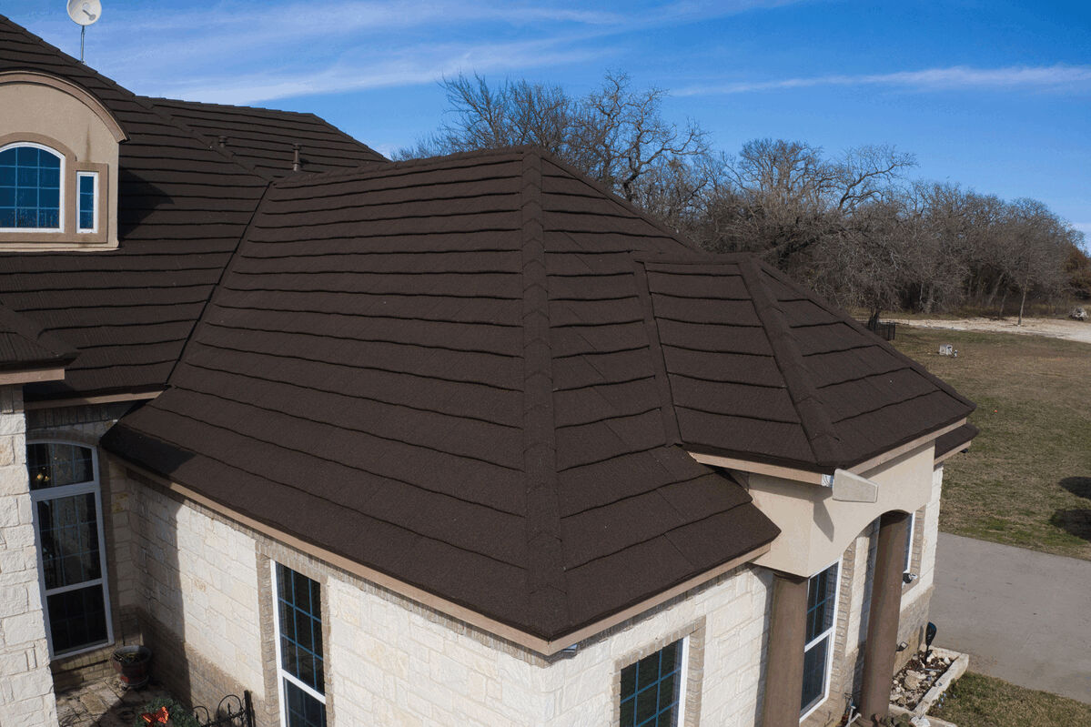 Close-up of dark brown metal roof tiles and ridges on a residential home.