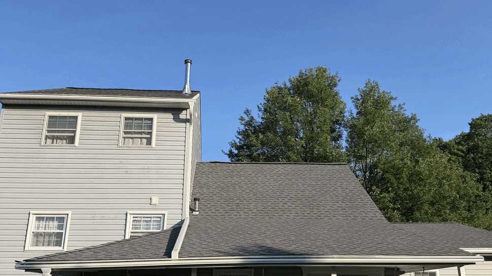 Covered porch with hanging plants and white gutters and downspout along the eave.