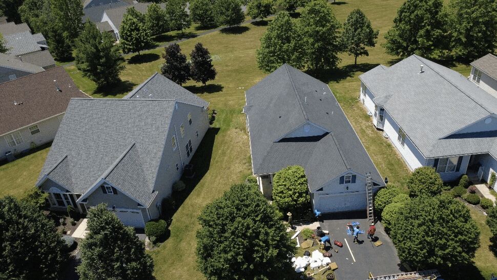Roof replacement staging and cleanup | Paramount Home Solutions Roofing crew staging materials on driveway during a residential roof project.
