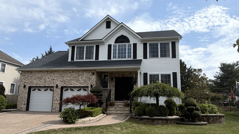Completed residential roof | Paramount Home Solutions Completed two-story home with a dark new roof, white siding, and manicured front lawn.