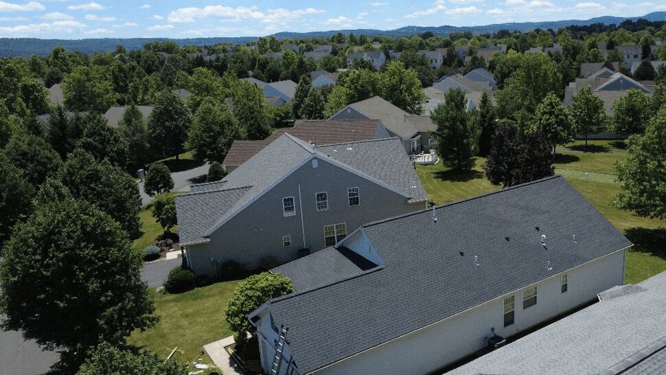 Aerial neighborhood view of completed residential roofs and yards.