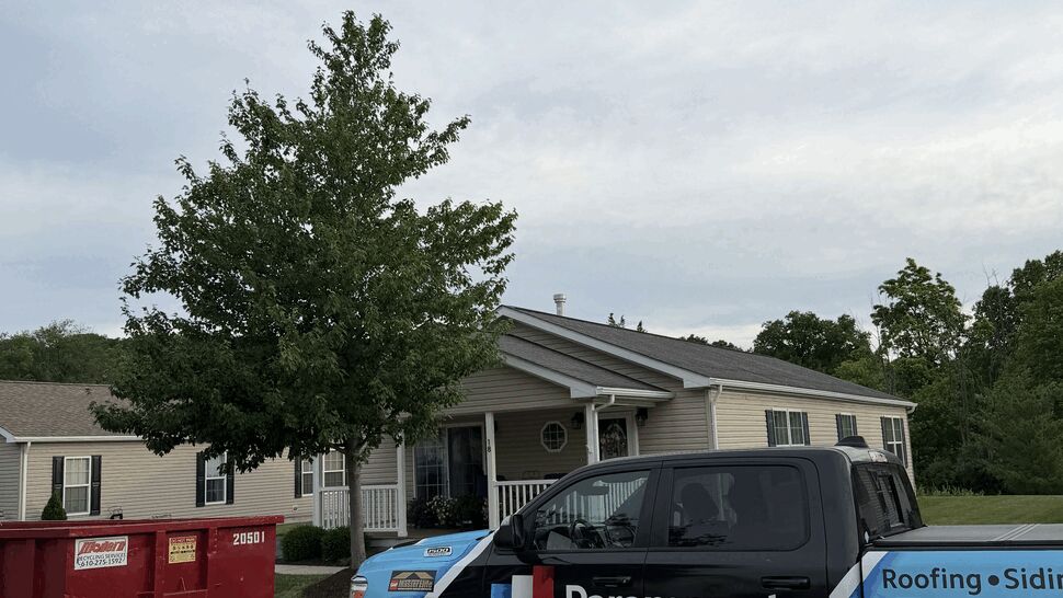 Paramount Home Solutions truck parked in front of a house next to a red dumpster.