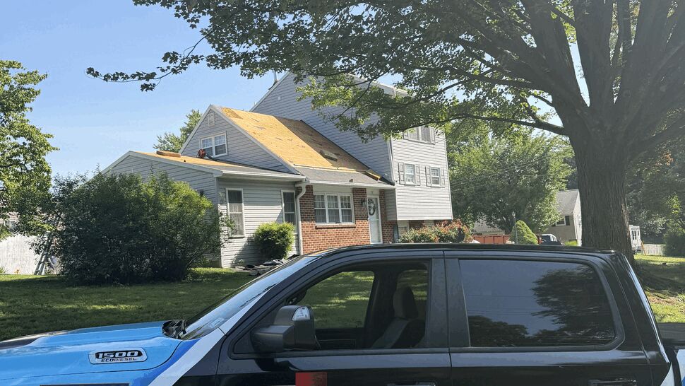 Paramount Home Solutions truck parked in front of a house with roof work visible.
