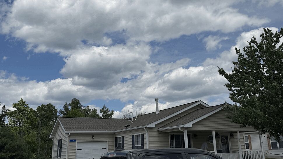 Paramount Home Solutions truck alongside a house showing siding and garage under a cloudy sky.