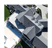 Aerial view of a large multi-gabled residential roof and backyard pool