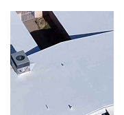 Close-up of a flat white roof section with an HVAC unit and vents