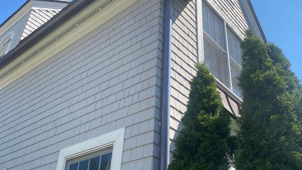 Corner Downspout and Gutters | C&N Construction Tall corner of house showing vertical downspout and roof gutter