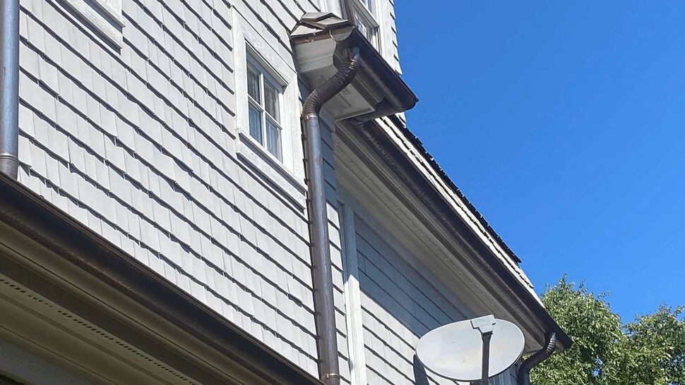 Roofline, Gutters and Downspout | C&N Construction Upper roofline with gutters, downspout and satellite dish visible