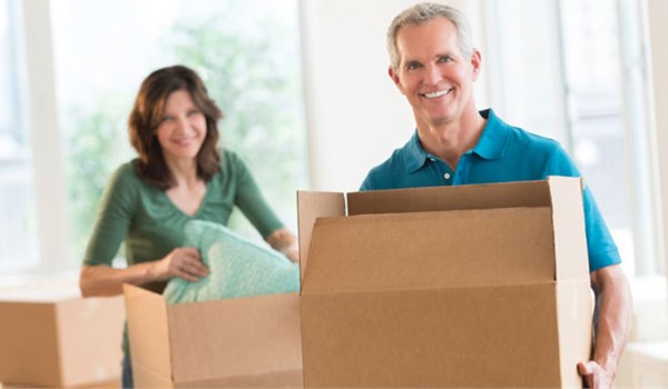Man and woman happily packing boxes for their upcoming move