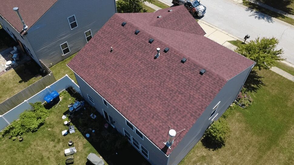 Angled aerial of home roof with multiple vents and chimney stack