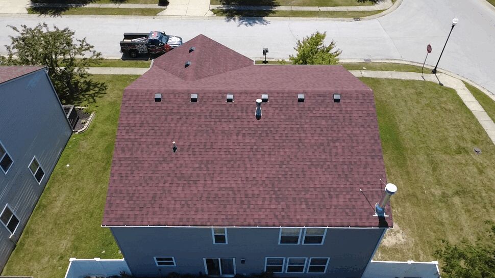 Top-down view of red shingle roof showing a neat line of vents