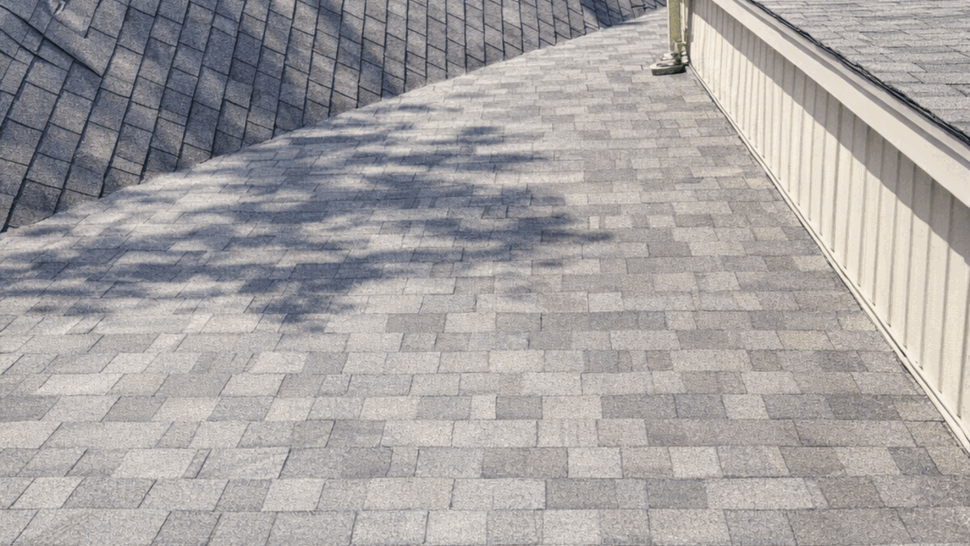 Roof valley with downspout junction on asphalt shingles seen from above