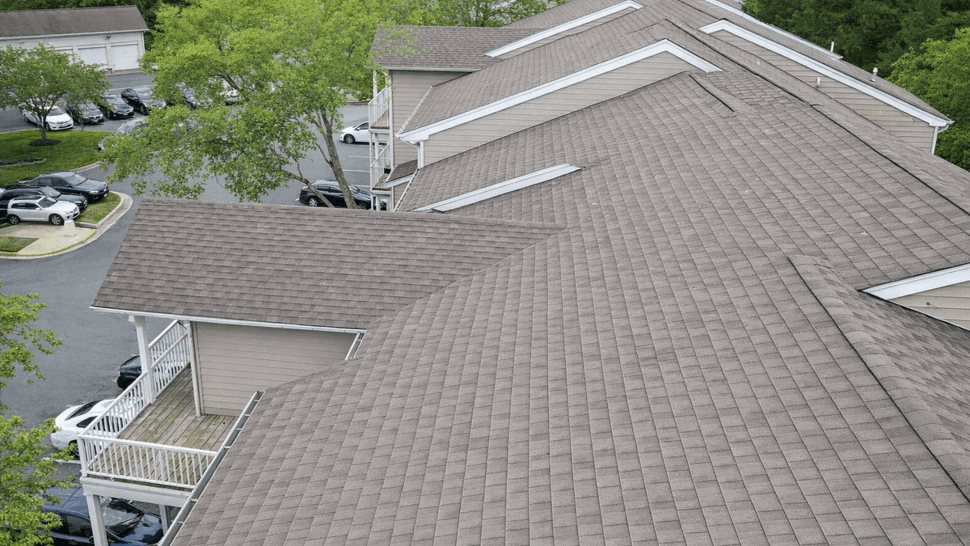 Aerial view of uniform asphalt shingle roofs on an apartment complex
