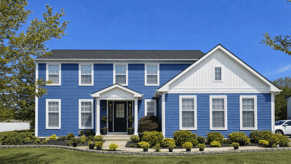 Blue Two-Story Home with New Siding | Tycos Roofing And Siding Inc Front view of a blue two-story house with white trim and a dark roof.